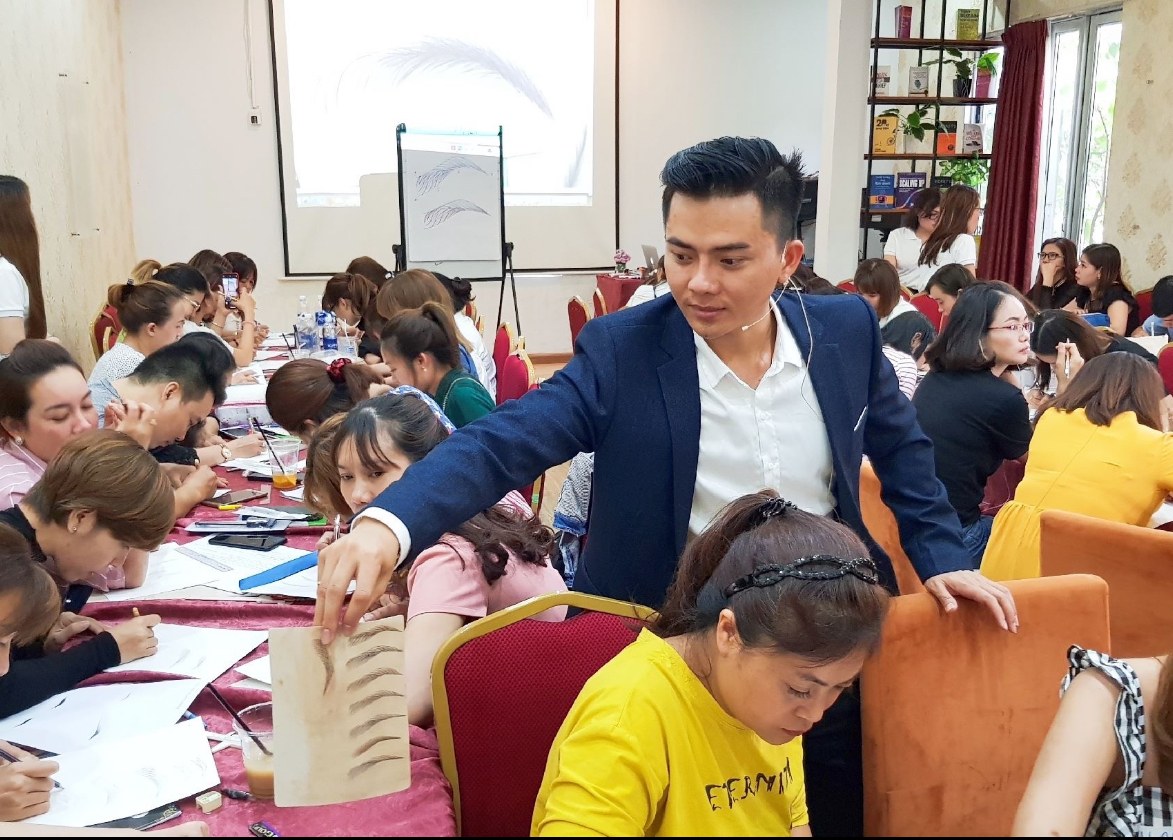 Bùi Phi Long hướng dẫn học viên trong lớp phun thêu